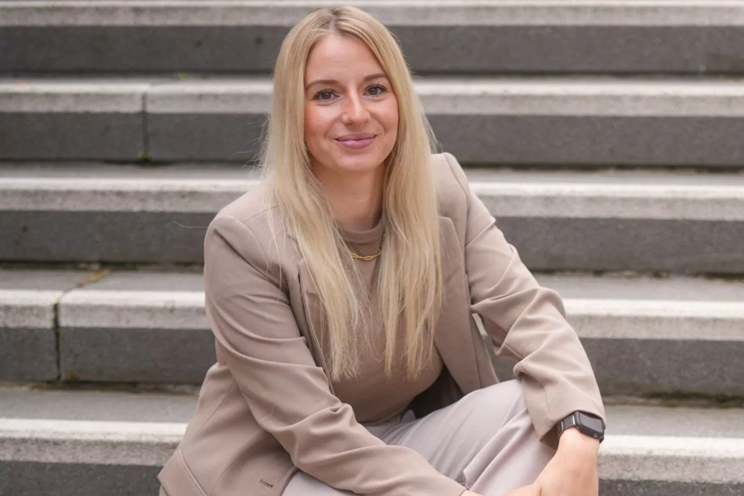Hannah lächelt dich auf einer Treppe sitzend